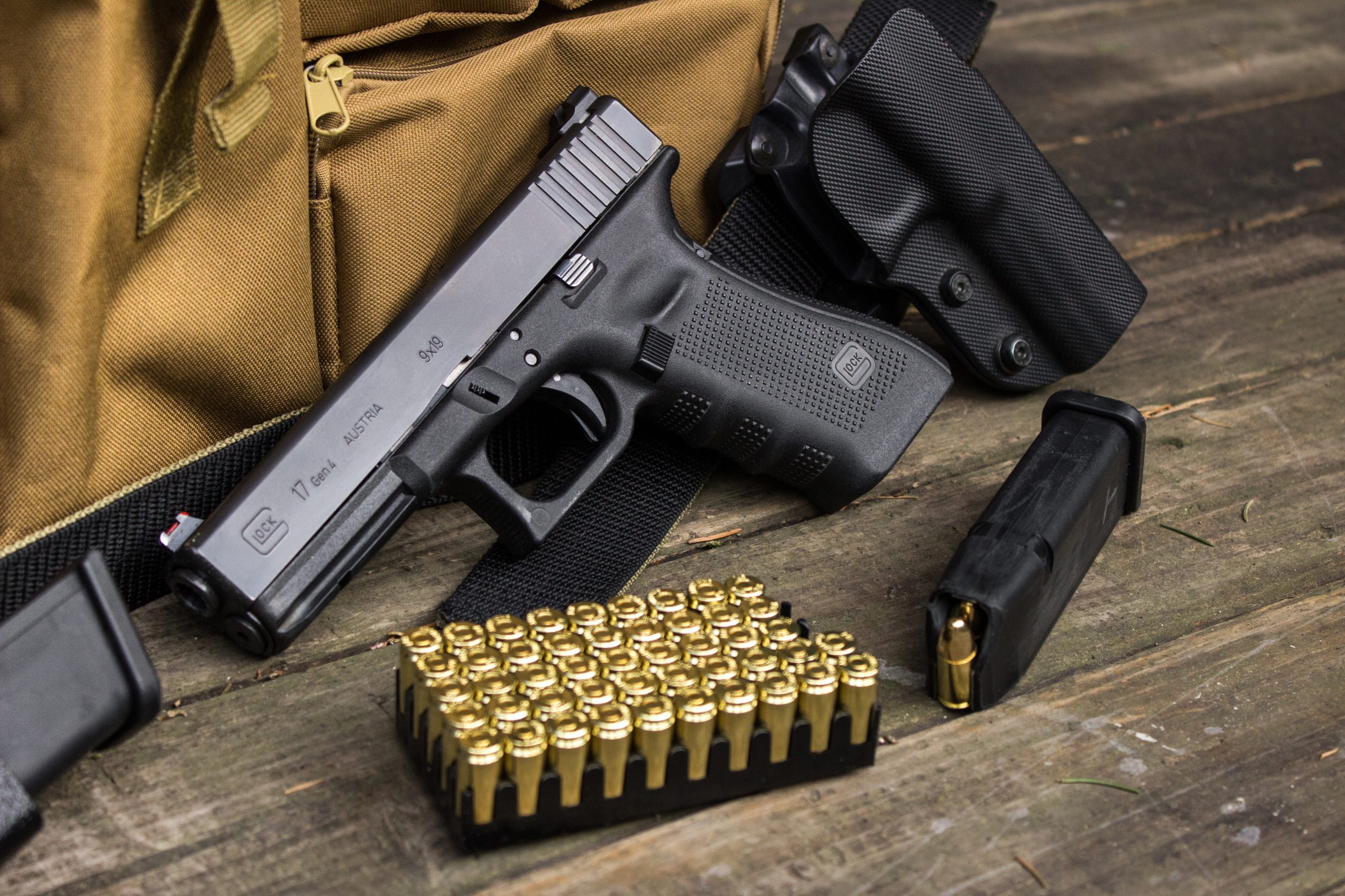 Glock handgun with spare magazine, bullets, and range bag.
