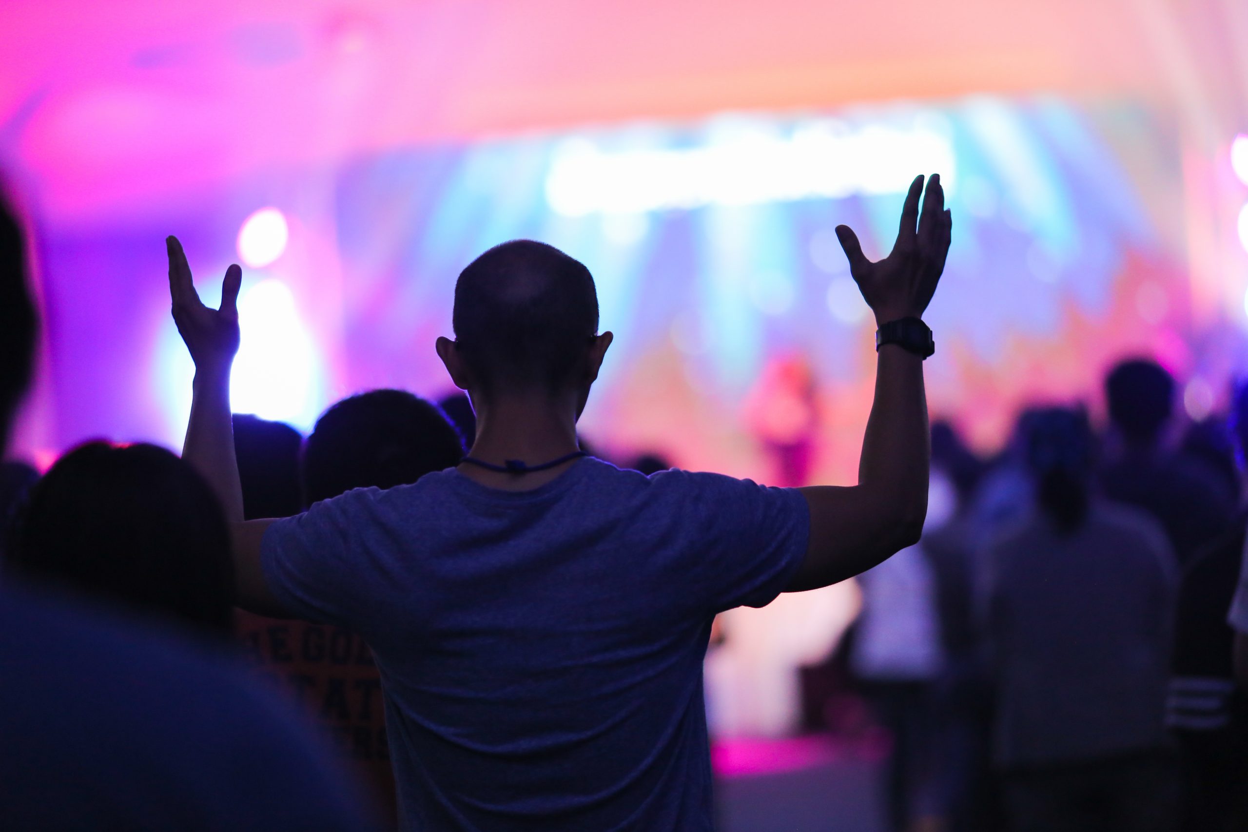 man lifts hands in worship