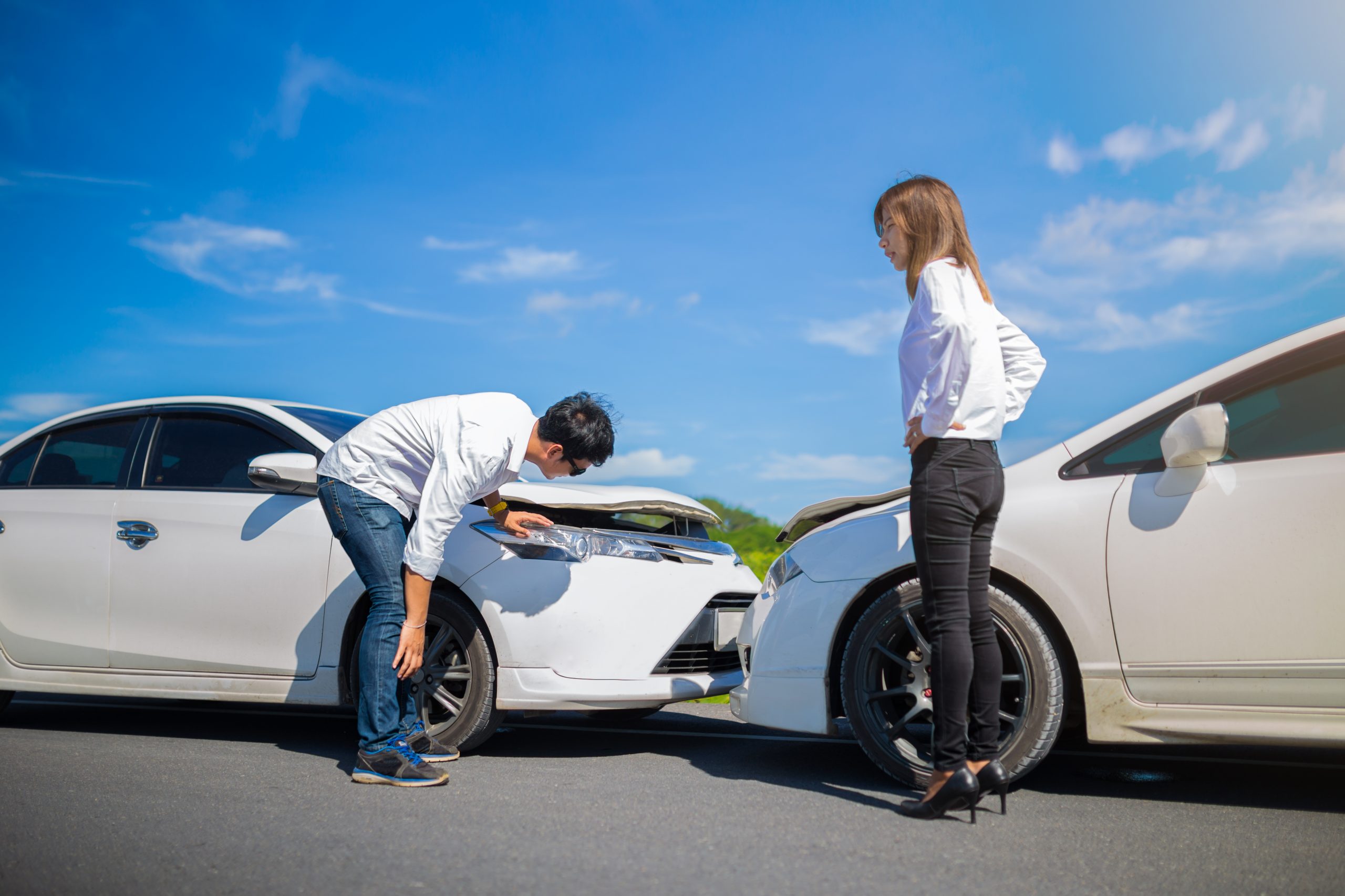 A fender bender with two cars and a man and a woman