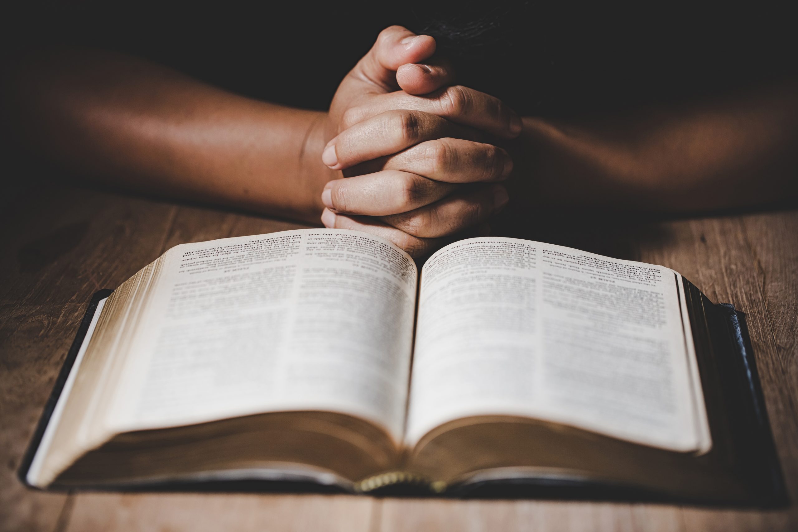 Folded hands and a bible signify prayer time