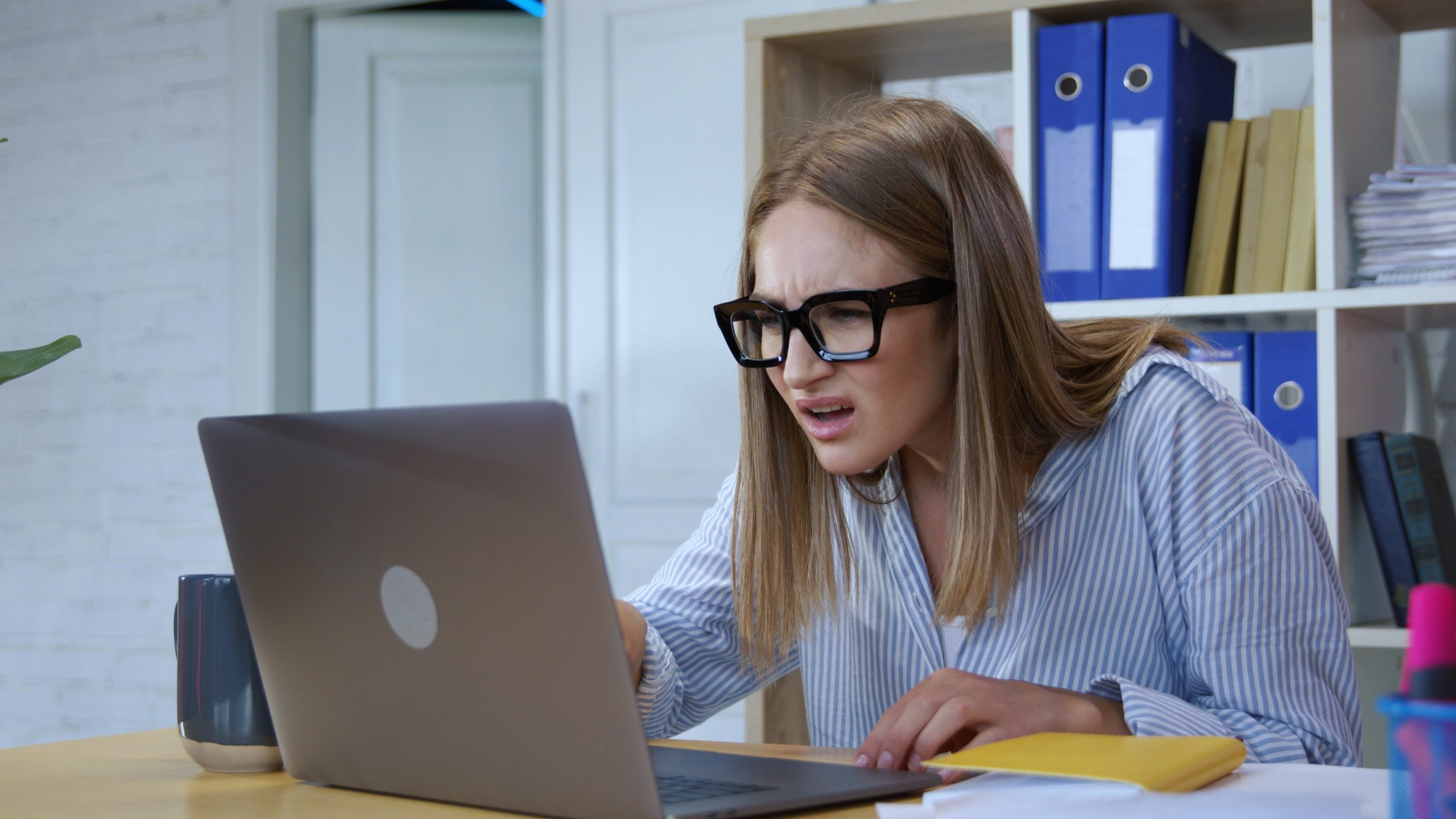 Woman working on laptop amazed at the stupidity of comments