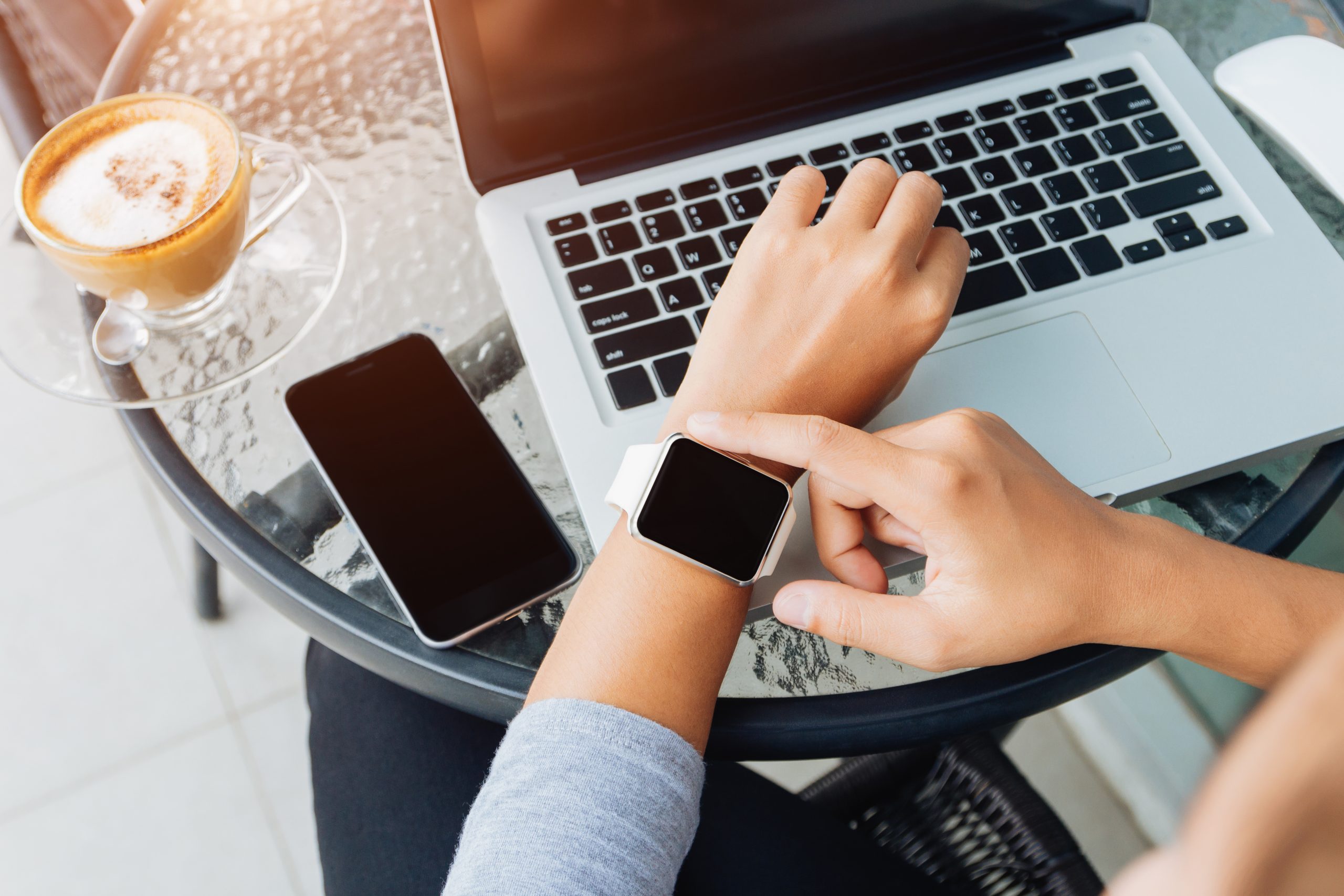 Member of the Apple Cult displays Macbook, iPhone, and Apple Watch