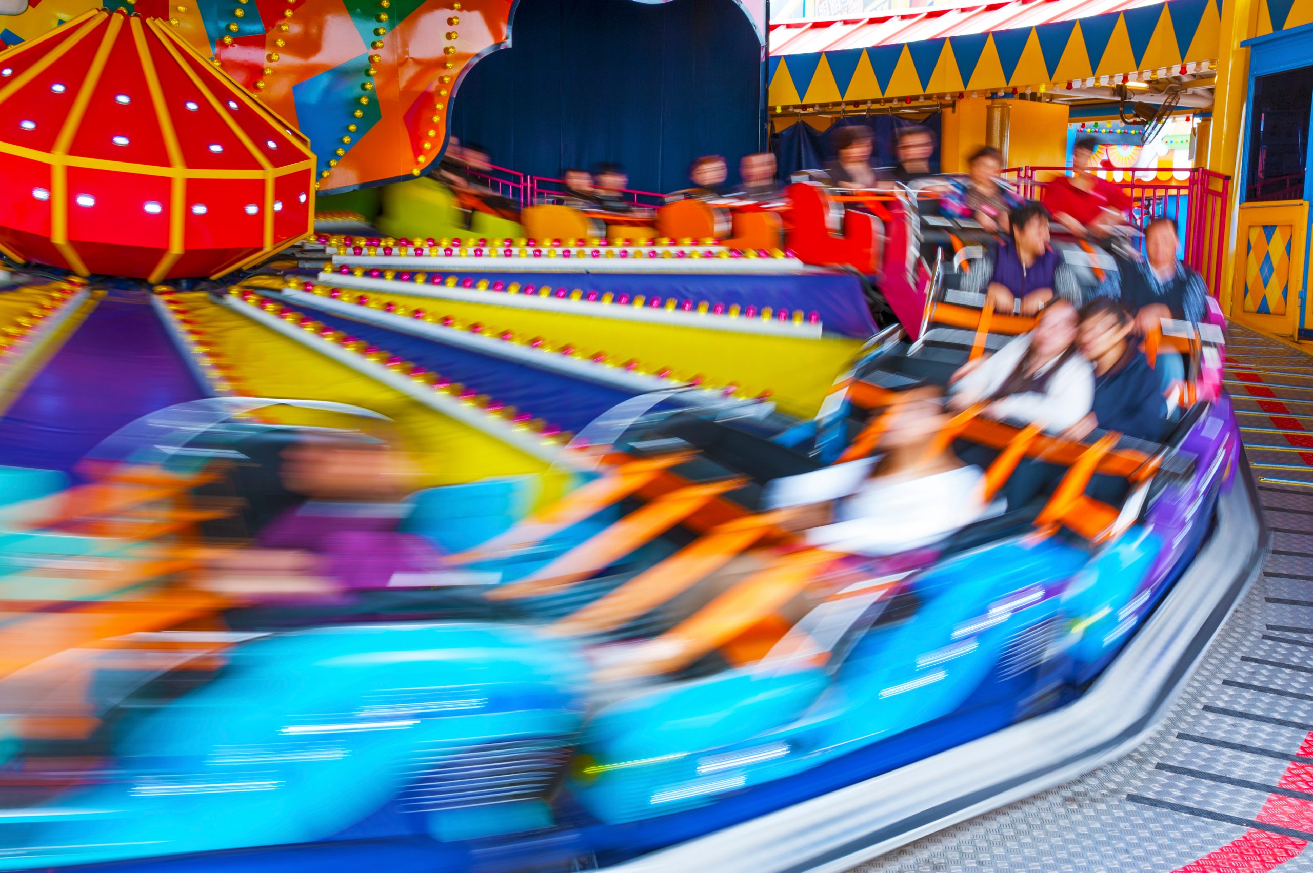 a carnival ride, possibly the himalaya, spins quickly with riders