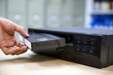 Man inserts VHC tape in the first VCR.