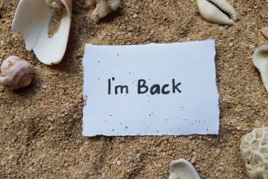 Note that says I'm Back on sandy beach.