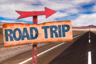 Wooden sign with arrow that says Road Trips.