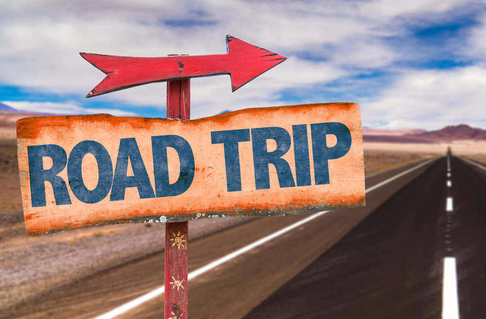 Wooden sign with arrow that says Road Trips.