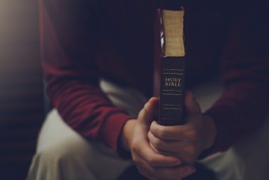 man holding Bible prays, portraying the message that he can rely on my faith