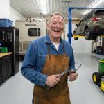 A male baby boomer enjoying his wrenching time in his garage.