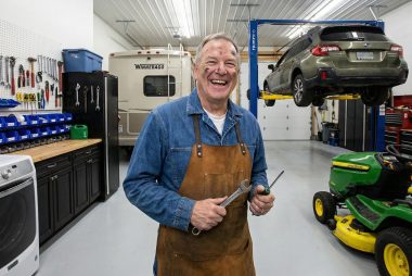 A male baby boomer enjoying his wrenching time in his garage.